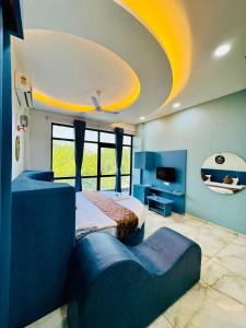 a large room with two beds and a tv at Hotel JD Fortune in Anand