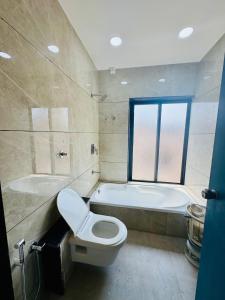 a bathroom with a toilet and a tub and a sink at Hotel JD Fortune in Anand