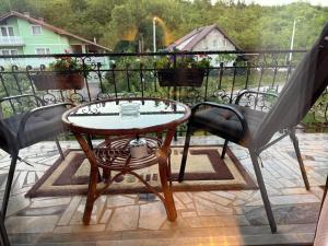 a table and two chairs on a balcony at Apartmani Hrastik 2 in Bihać