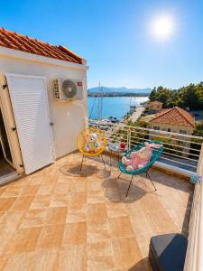 a balcony with two chairs and a view of the water at AB Preveza Apartments-15 Meters Over the Sea Attic & Alexander's the Great Executive Suite in Preveza