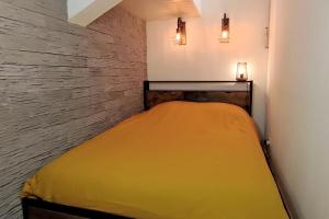 a small bedroom with a yellow bed in it at Chez Louis - Central Triplex in Rethel