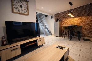 a living room with a large television and a table at Chez Louis - Central Triplex in Rethel