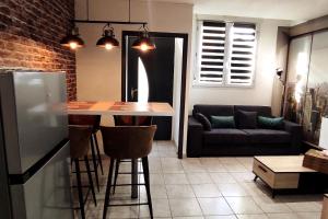 a kitchen with a table and a couch in a room at Chez Louis - Central Triplex in Rethel +4 photos