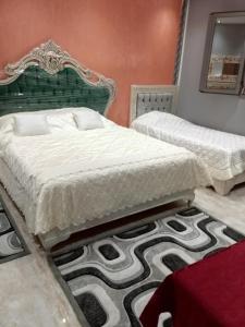 a bedroom with two beds and a green headboard at Mon cœur Gris-Or in Rejiche