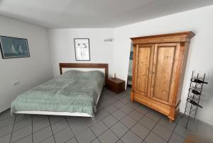 a bedroom with a bed and a wooden cabinet at Apartment Akazie in Weinsheim