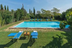 a swimming pool with blue chairs and a table at Agriturismo Bandinelli in Castiglione della Pescaia +26 photos