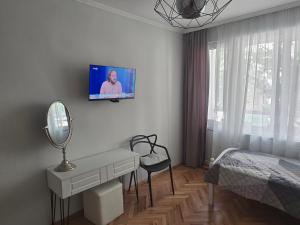 a bedroom with a desk and a tv on the wall at Sweet Home in Burgas