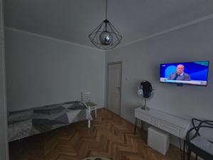 a room with a bed and a tv on the wall at Sweet Home in Burgas +8 photos