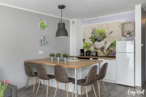a kitchen with a wooden table and chairs at Piastowska in Pobierowo