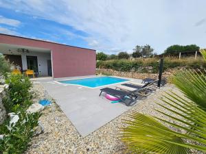 a swimming pool with two lounge chairs next to a building at Vila Dora with Private Pool in Radetići