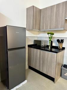 a kitchen with a black refrigerator and a counter at Revo Apartments in Lusaka