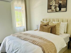 a bedroom with a bed with white sheets and pillows at Revo Apartments in Lusaka