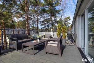 a patio with a table and chairs and a grill at Piastowska in Pobierowo
