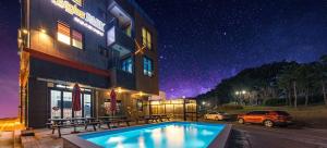 a hotel with a swimming pool in front of a building at Boryoung Eagle Spark Pension in Boryeong