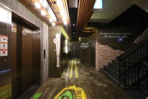 a hallway in a building with stairs and a sign on the wall at Boryoung Eagle Spark Pension in Boryeong