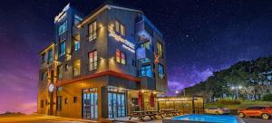 a building under a starry sky with cars parked in a parking lot at Boryoung Eagle Spark Pension in Boryeong