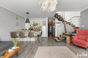 a living room with a dining room table and a staircase at Piastowska in Pobierowo