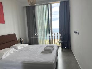 a bedroom with a bed with a view of the ocean at Green Coast 244d - by Ale Investa in Palasë