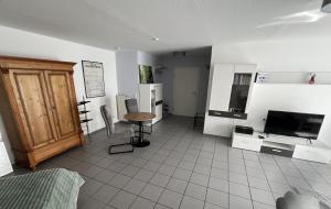 a living room with a television and a table in a room at Apartment Akazie in Weinsheim