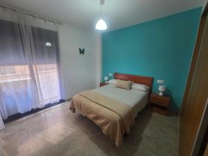 a bedroom with a bed and a blue wall at APARTAMENTO CONSTITUCIÓN in Benicarló +33 photos