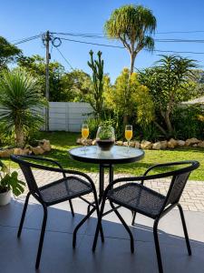 a table with two chairs and two glasses of wine at Garden View Suite in Gqeberha