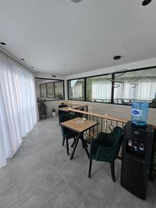 a dining room with tables and chairs and windows at Kamel Rooms & Apartments in Bijelo Polje