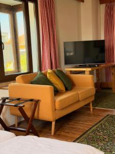 a living room with a couch and a flat screen tv at Gasthof Fersterer in Lamprechtshausen