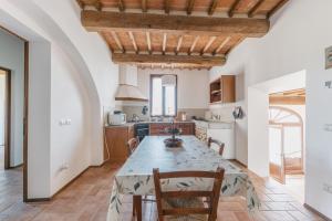 a kitchen and dining room with a large table and chairs at Agriturismo Melariano in Castelnuovo Berardenga