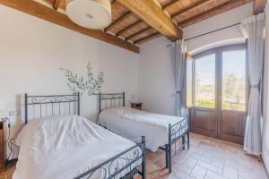 two beds in a bedroom with a window at Agriturismo Melariano in Castelnuovo Berardenga +108 photos