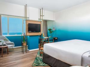 a hotel room with a bed and a flat screen tv at Mercure Rio Boutique Hotel Copacabana in Rio de Janeiro +91 photos