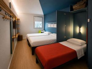 two beds in a room with blue walls at Ibis budget Dijon Centre Clemenceau in Dijon +63 photos