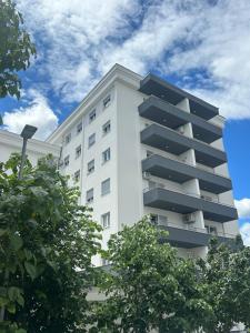 a white building with trees in front of it at Tiffany apartment - Podgorica in Podgorica