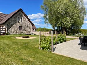a yard with a stone house and a fence at Holmens Guesthouse in Lemming