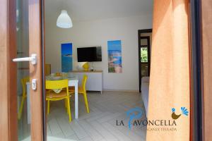 a living room with a table and yellow chairs at Case Vacanze La Pavoncella in Teulada