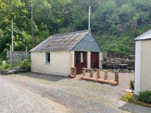 a small house on a gravel road with a fence at Yairbrig Holiday in Galashiels