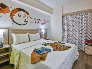 a hotel room with a bed with flowers on it at ibis Styles Vitoria da Conquista in Vitória da Conquista +83 photos