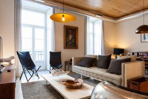 un soggiorno con divano e tavolo di JOIVY Downtown Design Apartments a Lisbona