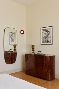 a bedroom with a wooden dresser and a mirror at Owston Hotel in Fremantle