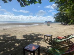 two chairs and two tables on a beach at Ocean View Tuggi Klong Prao in Klong Prao Beach