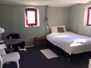 a bedroom with a bed and a desk and a window at Holmens Guesthouse in Lemming +44 photos
