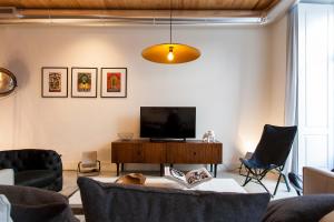 uma sala de estar com uma televisão e um sofá em ALTIDO Downtown Design Apartments em Lisboa