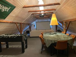 a conference room with a table and a piano at Holmens Guesthouse in Lemming