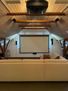 a living room with a couch and a projection screen at Holmens Guesthouse in Lemming