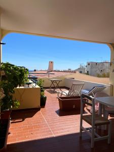 a patio with two chairs and a table on a roof at Olhos do mar 209 grande terraço vista mar in Olhos de Água