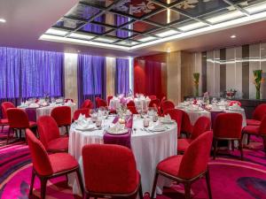 a banquet room with tables and red chairs at Mercure Hai Phong in Hai Phong +204 photos