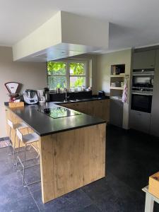 a kitchen with a large island with a black counter top at Maison l'amitié in Ellezelles