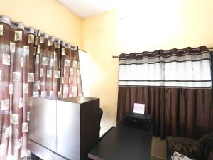 a living room with a television and a curtain at Hotel O Celebrity in Chandrapur +34 photos