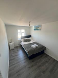 a bedroom with a bed and a wooden floor at Favour homes in Manchester