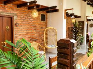 a patio with wicker chairs and a brick wall at Palm Mansion Boutique Suites in George Town