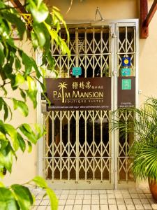 a gate with a sign in front of a building at Palm Mansion Boutique Suites in George Town +10 photos